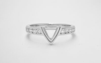 A 10 stone channel set round brilliant cut diamond ring shaped with a central double 'V' wire to fit with a marquise diamond engagement ring.