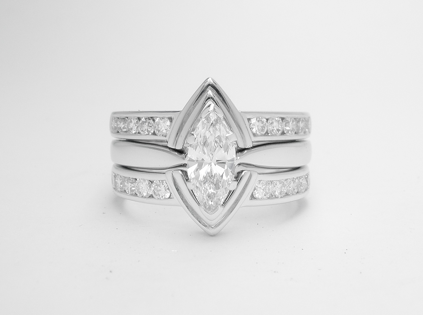 A pair of 10 stone channel set round brilliant cut diamond ring shaped with a central double 'V' wire to fit with a marquise diamond engagement ring.
