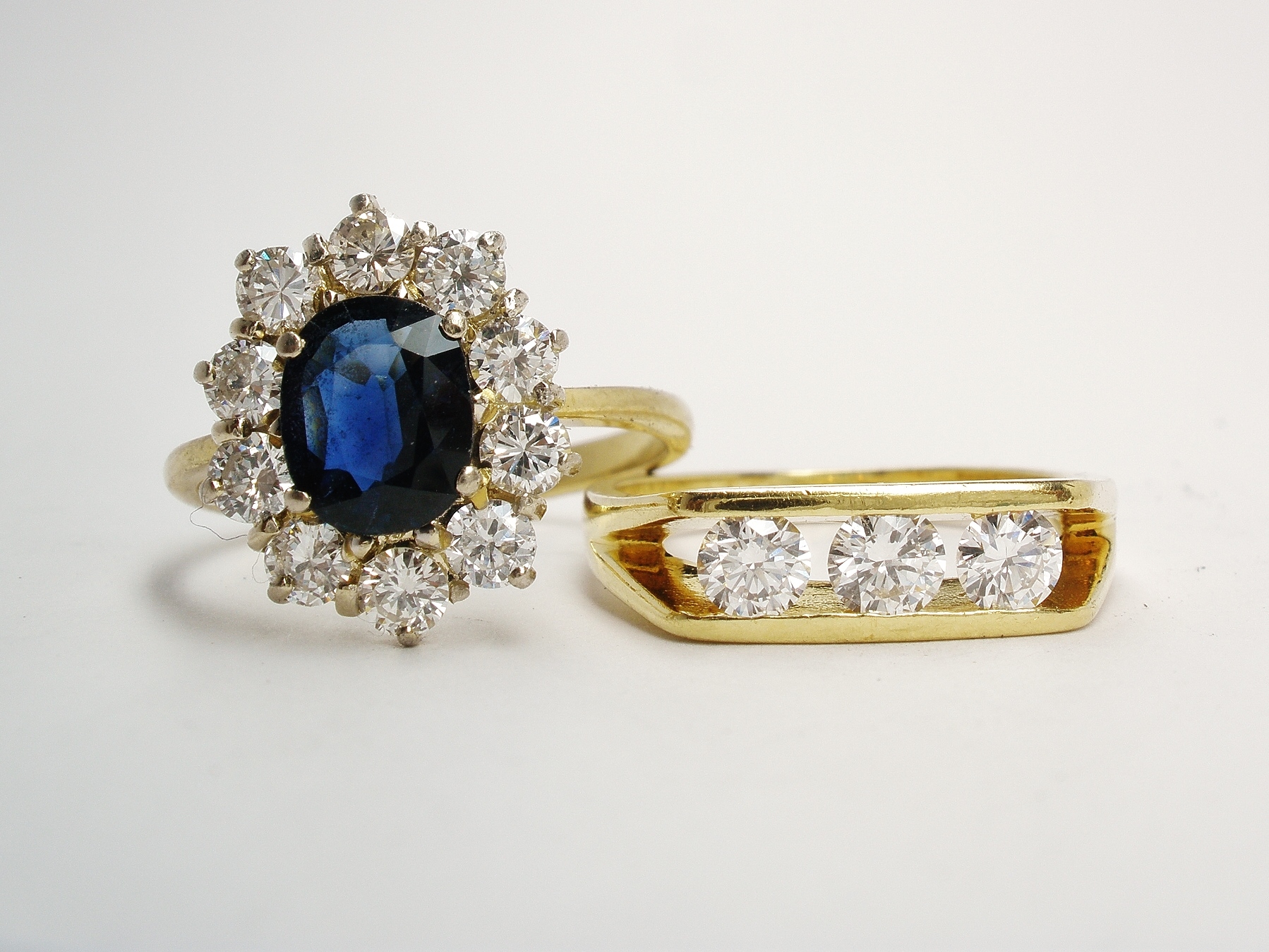 A 3 stone round brilliant cut diamond ring and an 11 stone oval sapphire and diamond cluster. Only the diamonds were to be used.