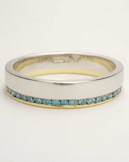 A 26 stone Sky Blue and white round brilliant cut diamond offset style wedding ring mounted in platinum and 18ct. yellow gold.