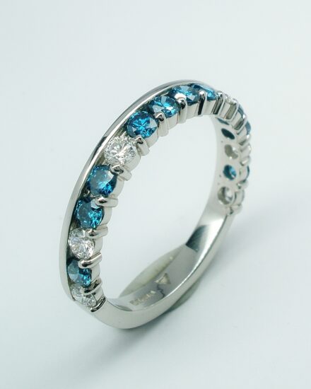 A 16 stone Sky Blue and white round brilliant cut diamond part channel set wedding ring. The pattern of Blue to white is 4 blue, 1 white, 2 blue, 1 white, 1 blue, 1 white.