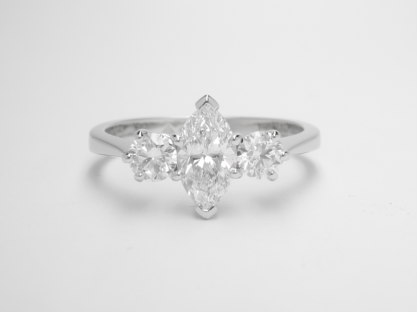 A 3 stone marquise cut and round brilliant cut diamond ring mounted in platinum.