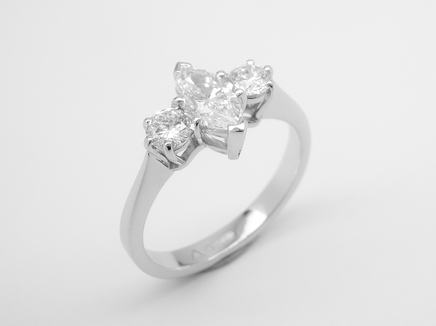 A 3 stone marquise cut and round brilliant cut diamond ring mounted in platinum.