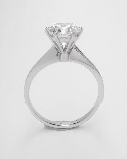 Before, a 1.90ct. single round brilliant cut diamond set in a 4 heavy clawed setting with no support bearer for the diamond and a low parallel shank. After, the 1.90ct. round brilliant cut diamond set in a finer clawed 6 claw setting with support bearer and a tapered knife edged shank with an elegant height.