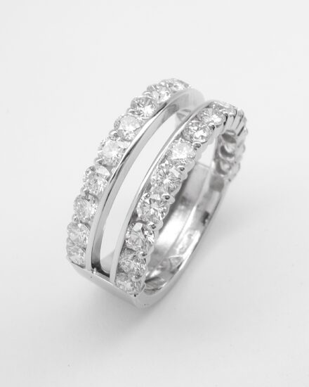 A platinum 28 stone round brilliant cut diamond part channel set double wedding ring with slot to insert single stone diamond engagement ring.