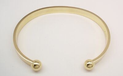 A gents 9ct yellow gold torque bangle with solid ball ends.