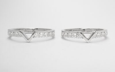 A pair of 10 stone round brilliant cut part channel set wedding rings shaped with a central 'V' shaped panel to fit around a single stone marquise diamond ring. The pair of 10 stone part channel set rings fitting with the single stone marquise diamond ring.