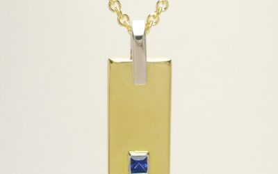 A 2 stone square cut sapphire and baguette diamond pendant mounted in 18ct. yellow gold and platinum.