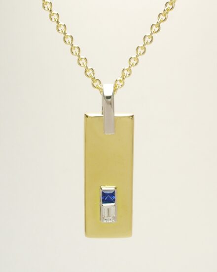 A 2 stone square cut sapphire and baguette diamond pendant mounted in 18ct. yellow gold and platinum.