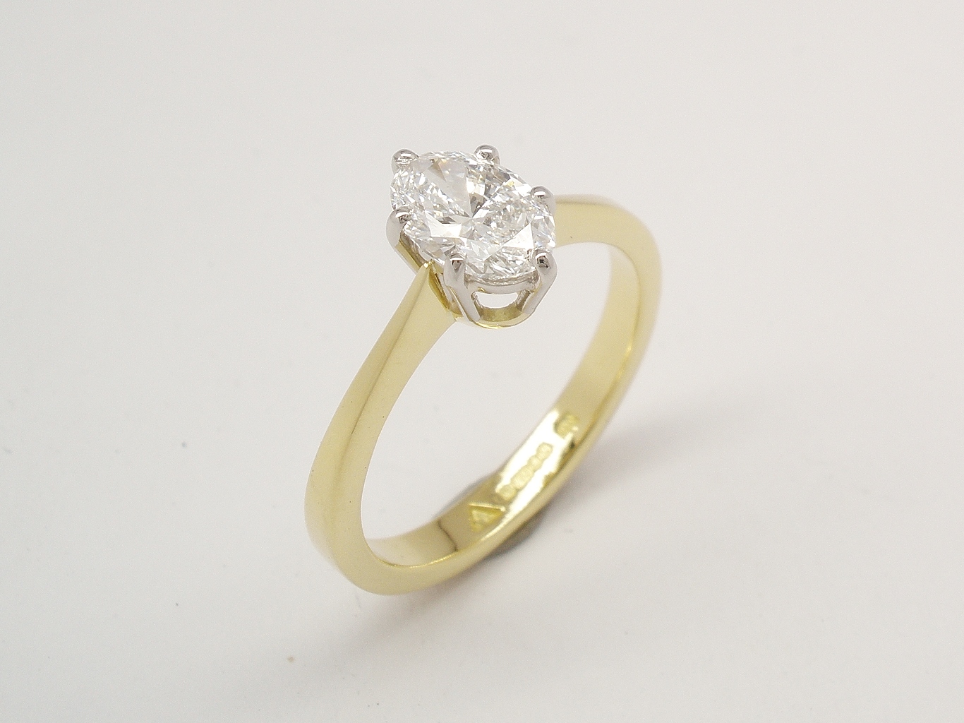 A single stone 0.50ct., 'E' colour, VVS2 clarity oval diamond ring mounted in 18ct. yellow gold and platinum.