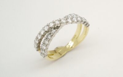 A 29 stone round brilliant cut diamond 'X' style cross-over ring mounted in 18ct. yellow gold and platinum.
