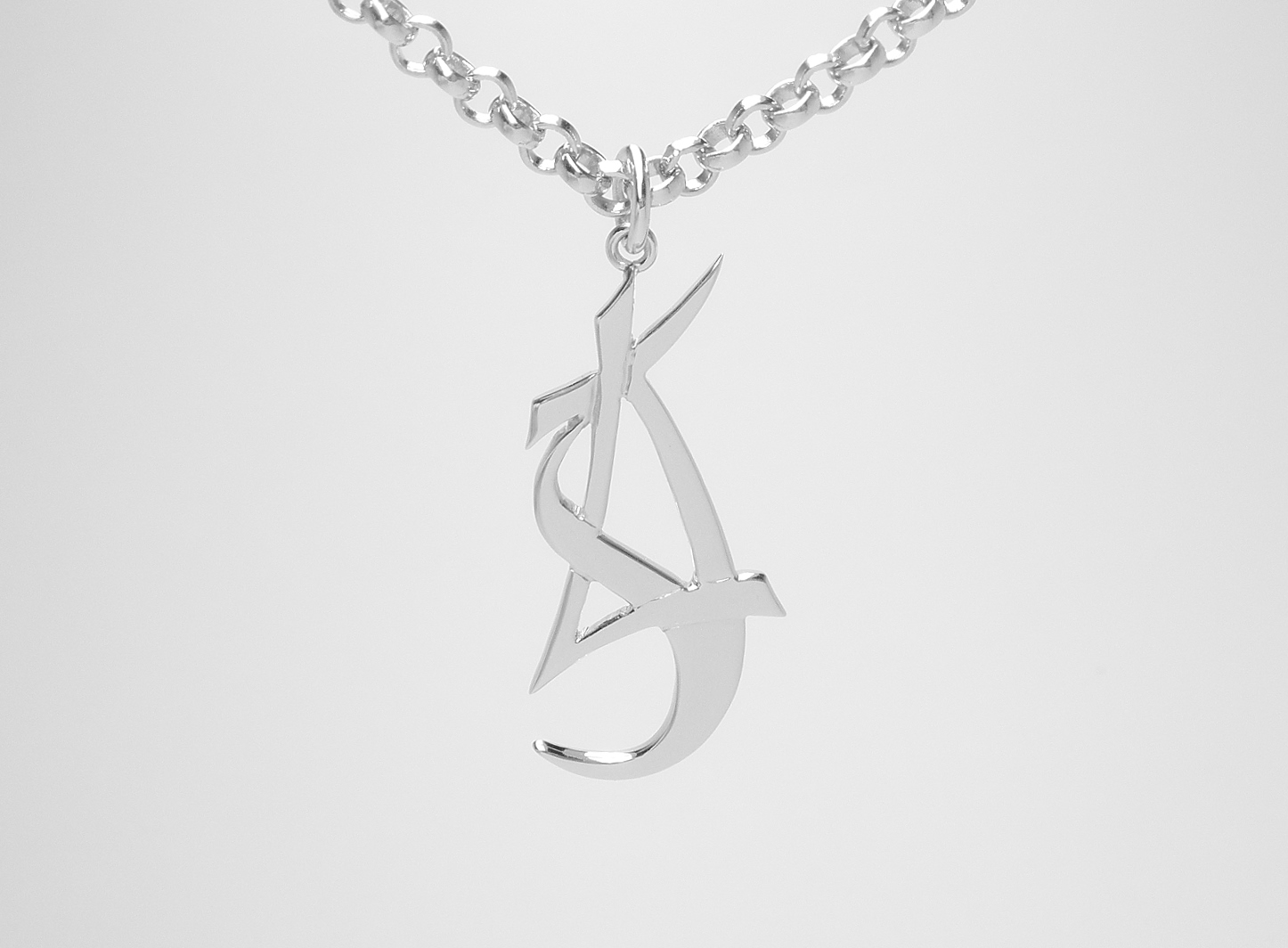 A 9ct. white gold stylised initial ' L, S, J ' pendant.