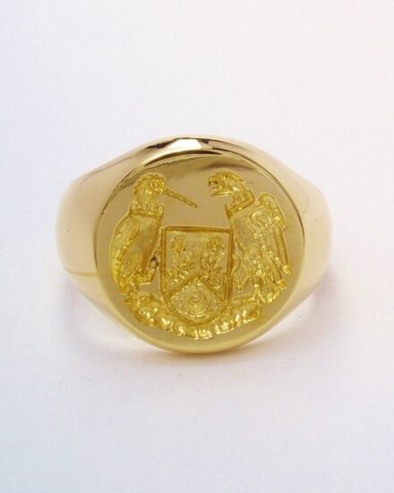 A 9ct. yellow gold round signet ring with a hand carved seal engraving, engraved as a mirror image.