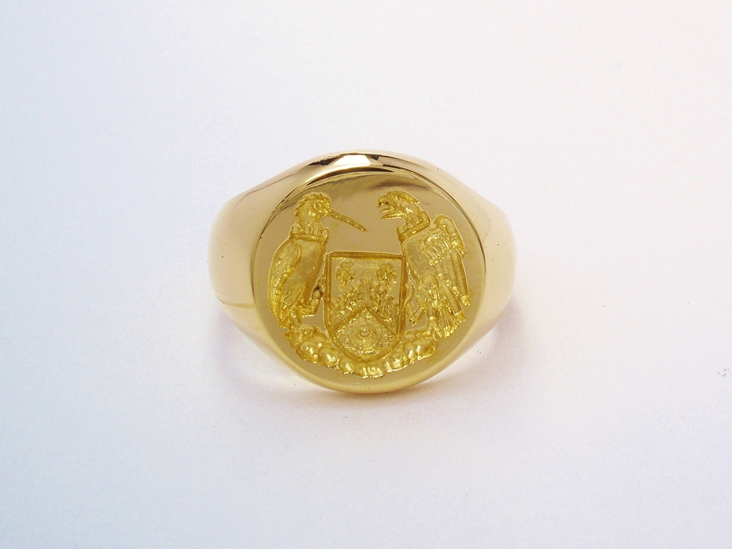 A 9ct. yellow gold round signet ring with a hand carved seal engraving, engraved as a mirror image.