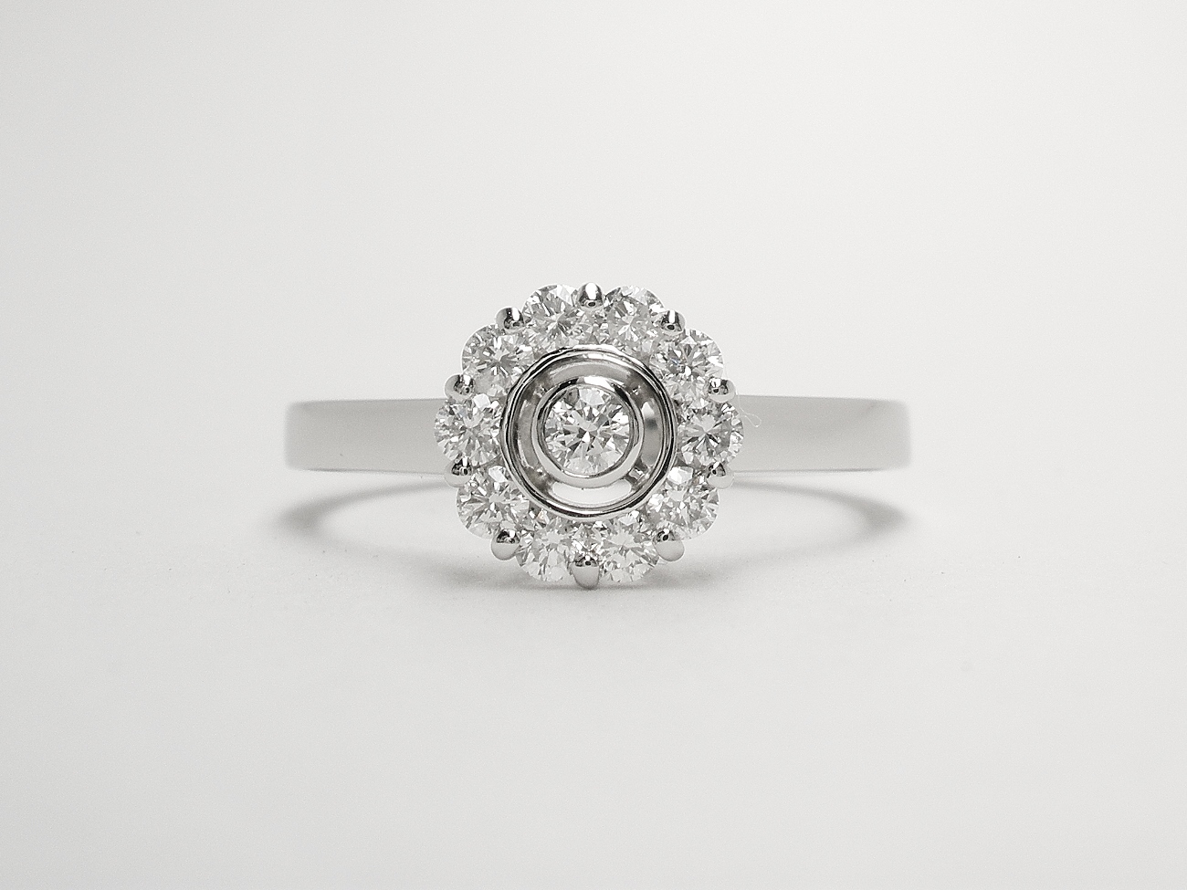 An 11 stone round brilliant cut diamond 'Halo' style cluster ring mounted in platinum.
