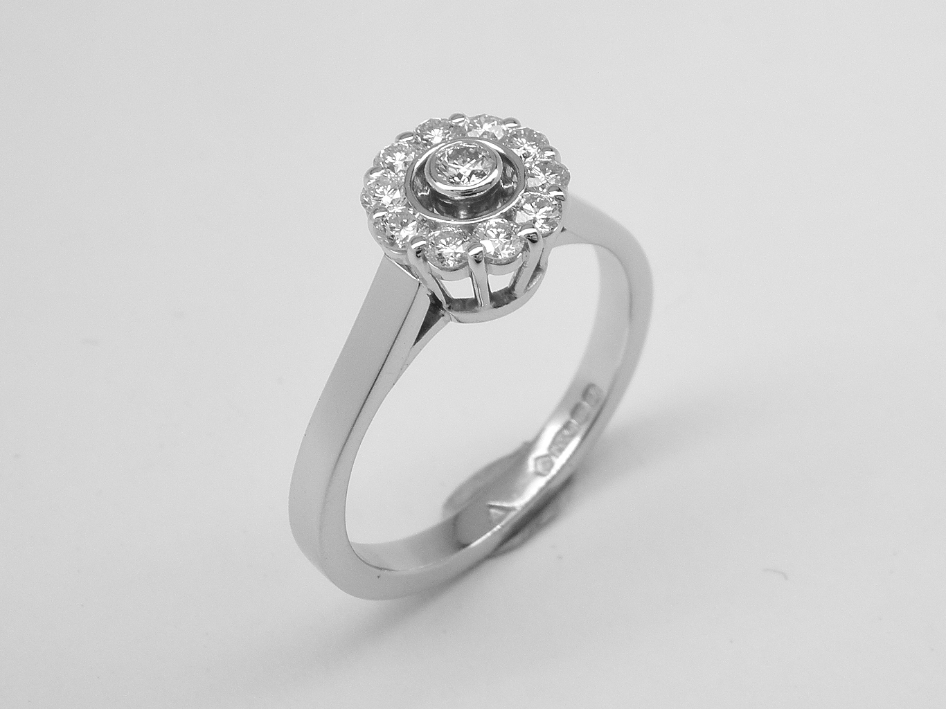 An 11 stone round brilliant cut diamond 'Halo' style cluster ring mounted in platinum.