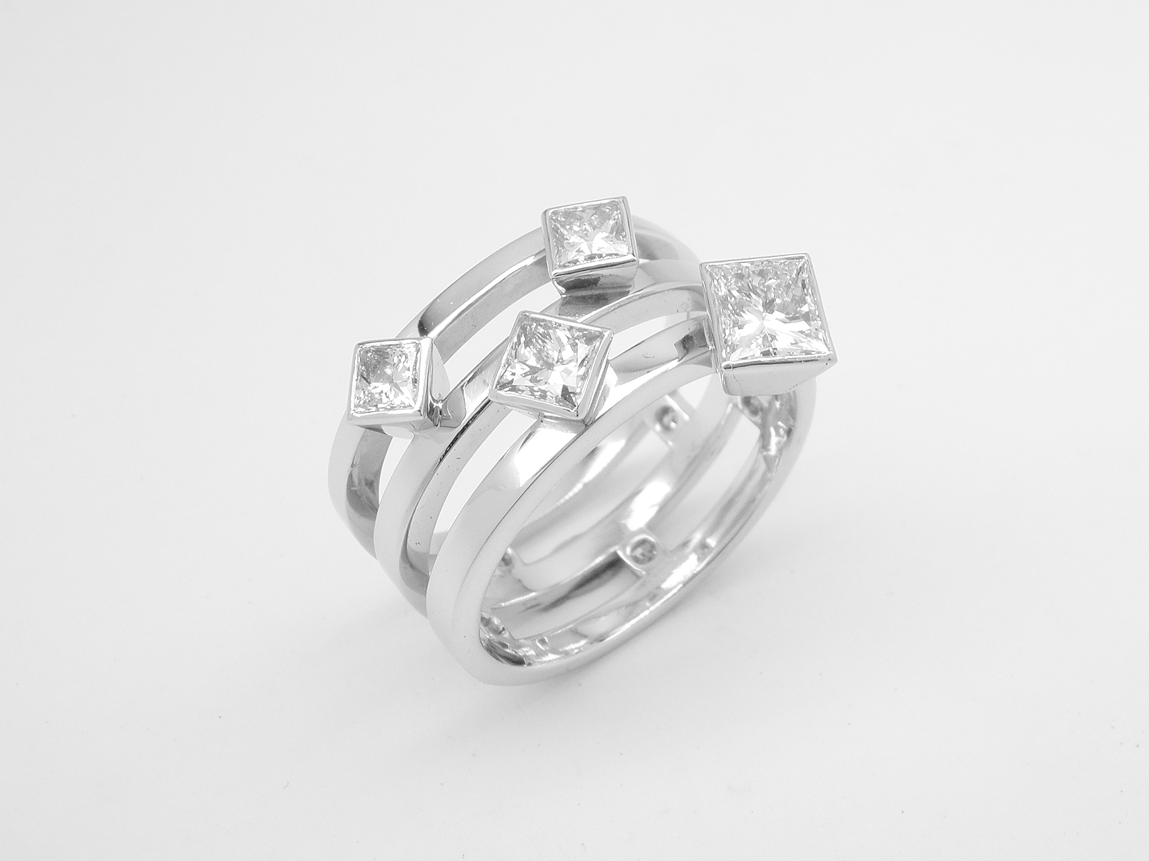 9 stone princess cut triple banded ring with the 4 larger diamonds rub-over set across the top and the 5 smalls set between the bands at the back