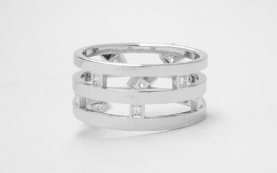 9 stone princess cut triple banded ring with the 4 larger diamonds rub-over set across the top and the 5 smalls set between the bands at the back