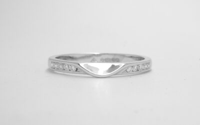 10 stone channel set round brilliant cut platinum wedding ring shaped to fit with single stone round brilliant cut