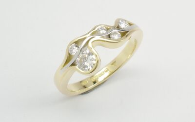 A 5 stone round brilliant cut diamond 'Wave' style ring mounted in 18ct. yellow gold and platinum.