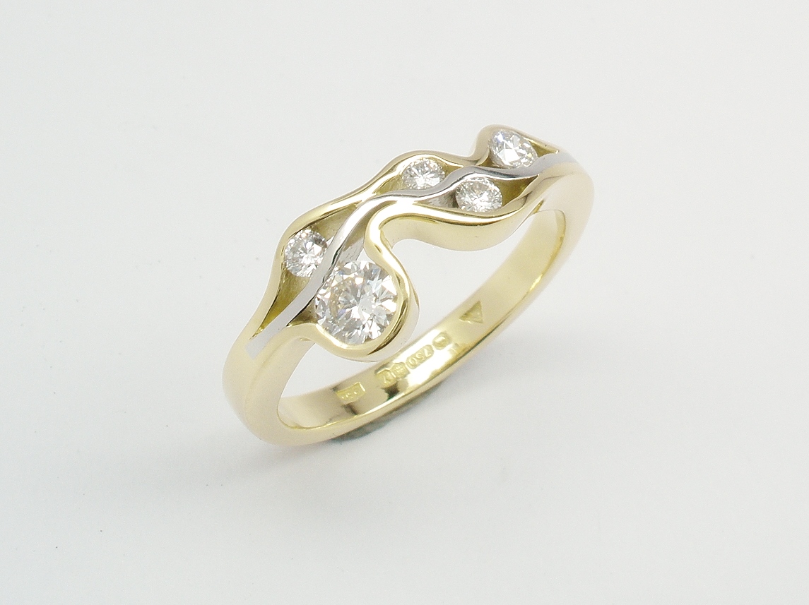 A 5 stone round brilliant cut diamond 'Wave' style ring mounted in 18ct. yellow gold and platinum.