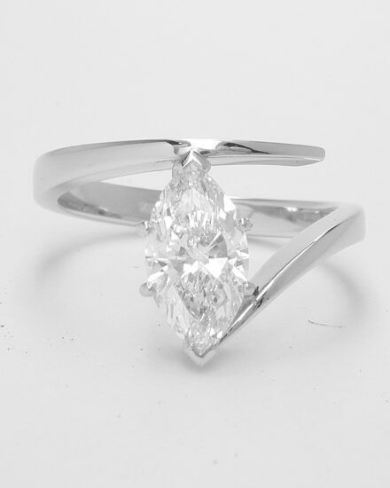 A single stone marquise diamond straight wishbone cross-over style ring mounted in platinum.