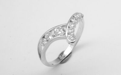 A 9 stone round brilliant cut diamond both channel set and part channel set wishbone style ring mounted in platinum.