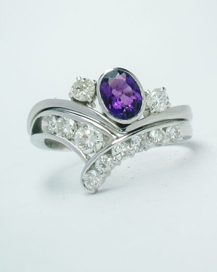 A 3 stone amethyst and round brilliant cut diamond wishbone style ring mounted in platinum and shaped to fit in with a 9 stone diamond wishbone ring.