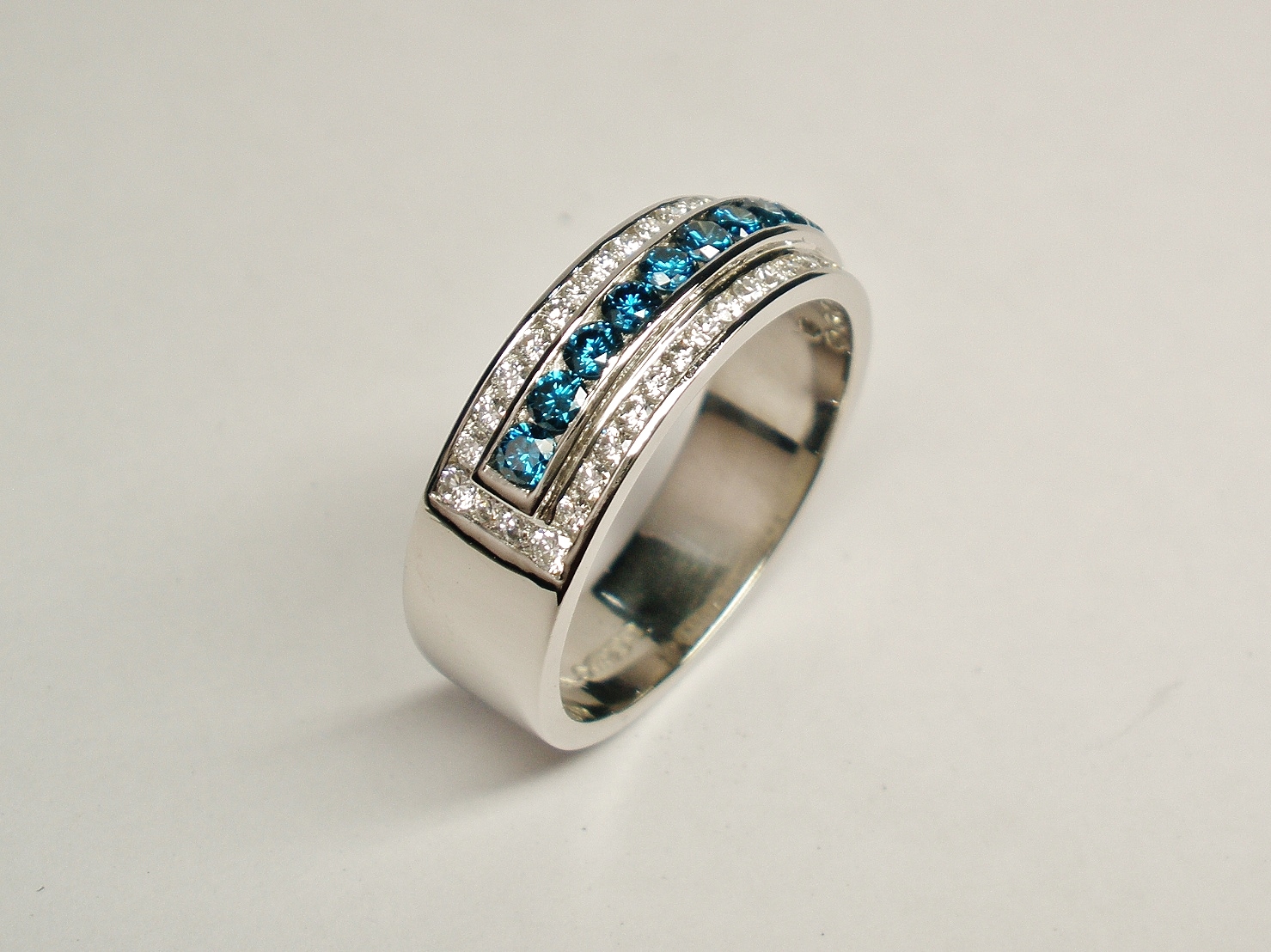 3a. A 53 stone channel set ocean blue and white round brilliant cut diamond ring mounted in platinum. The ocean blue diamonds are raised a little higher across the top.