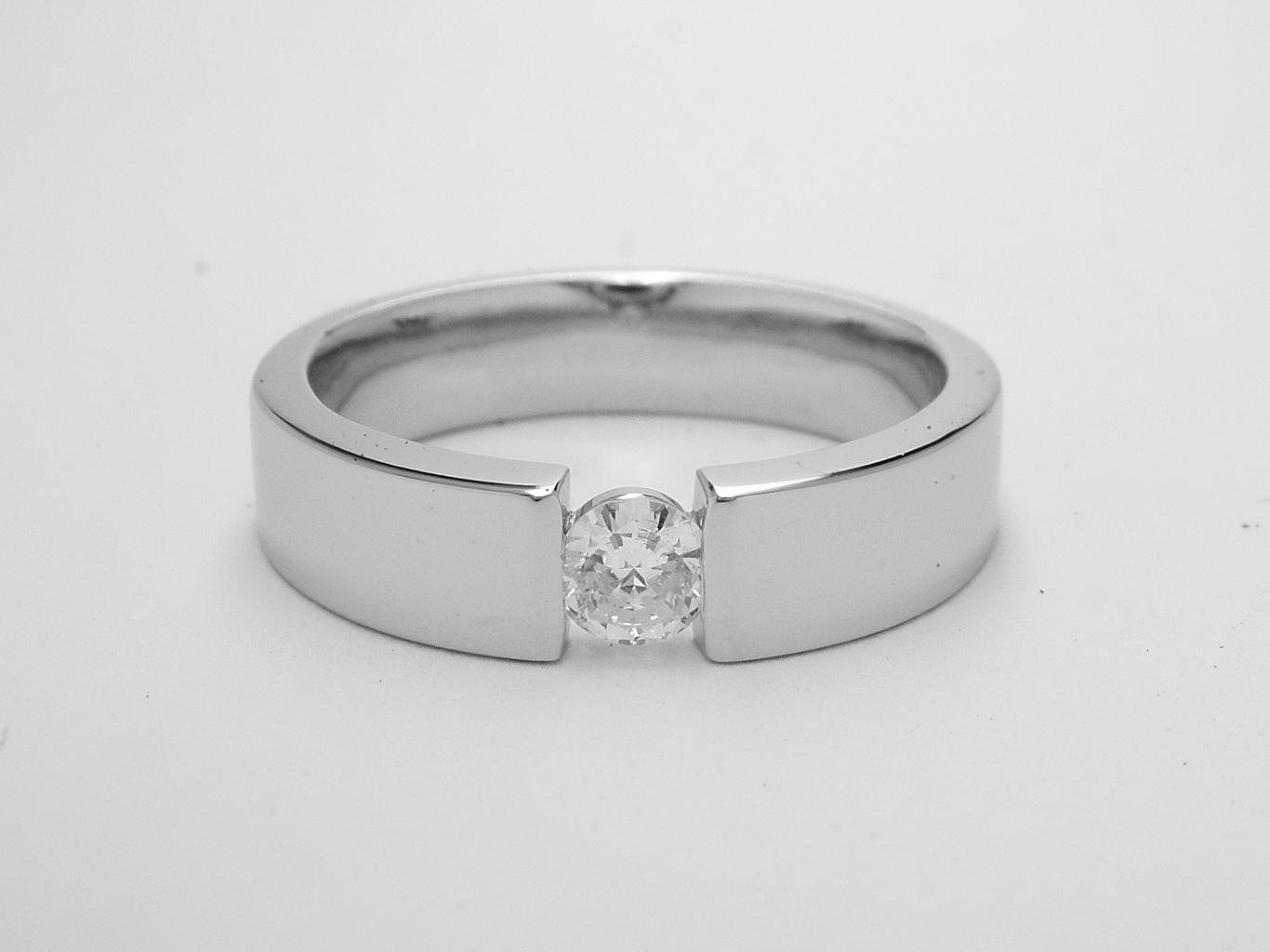 A single stone round brilliant cut diamond ring styled with the illusion of being tension set and mounted in platinum.