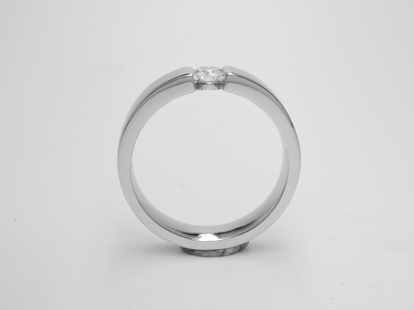 A single stone round brilliant cut diamond ring styled with the illusion of being tension set and mounted in platinum.