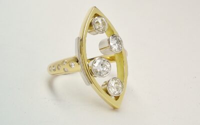 A 4 stone Victorian cut and round brilliant cut diamond marquise shaped ring mounted in 18ct. yellow gold and platinum with small brilliant cut round diamonds flush set in the shoulders.