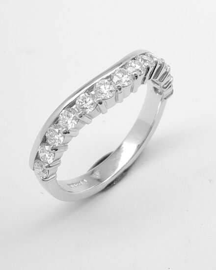 A pair of 13 stone, part channel set round brilliant cut diamond rings mounted in platinum and shaped to fit around a single stone engagement ring with diamond shoulders.