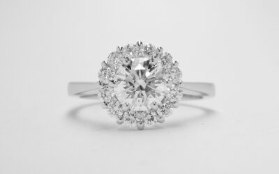 A 13 stone round brilliant cut diamond cluster mounted in platinum with a solid knife edged shoulder shank.