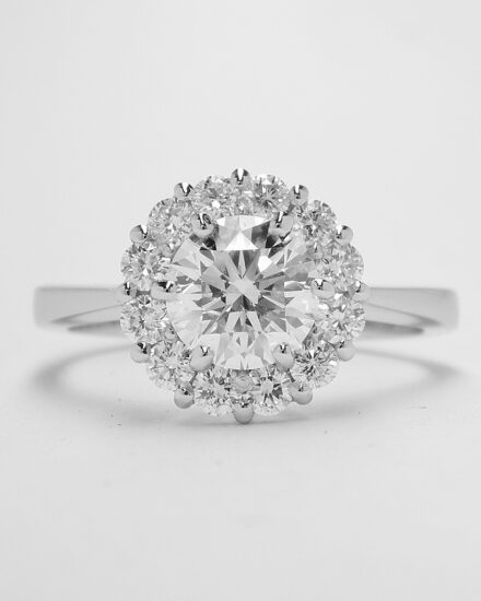 A 13 stone round brilliant cut diamond cluster mounted in platinum with a solid knife edged shoulder shank.