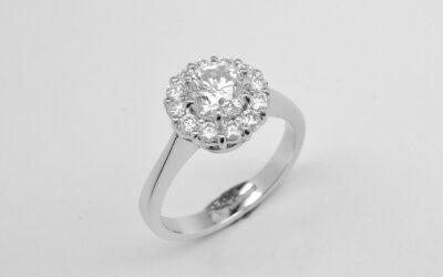 A 13 stone round brilliant cut diamond cluster mounted in platinum with a solid knife edged shoulder shank.