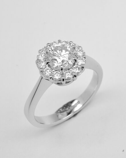 A 13 stone round brilliant cut diamond cluster mounted in platinum with a solid knife edged shoulder shank.