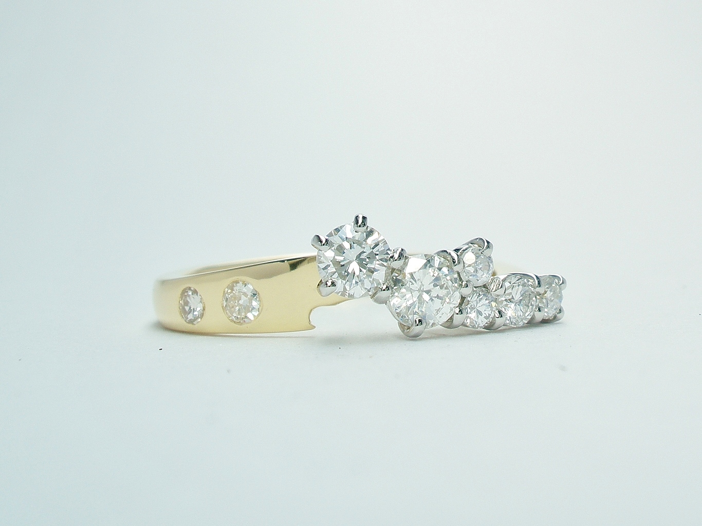 An 8 stone diamond ring mounted in 18ct. yellow gold and platinum shaped to fit with a single stone diamond ring.