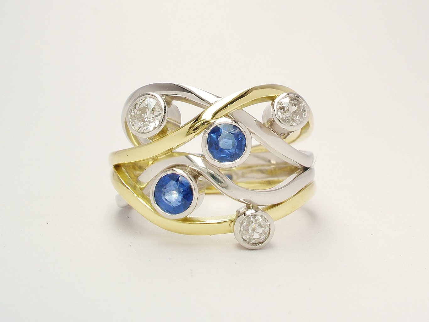 A 5 stone round sapphire and brilliant cut diamond 4 banded ring mounted in 18ct yellow gold and platinum.