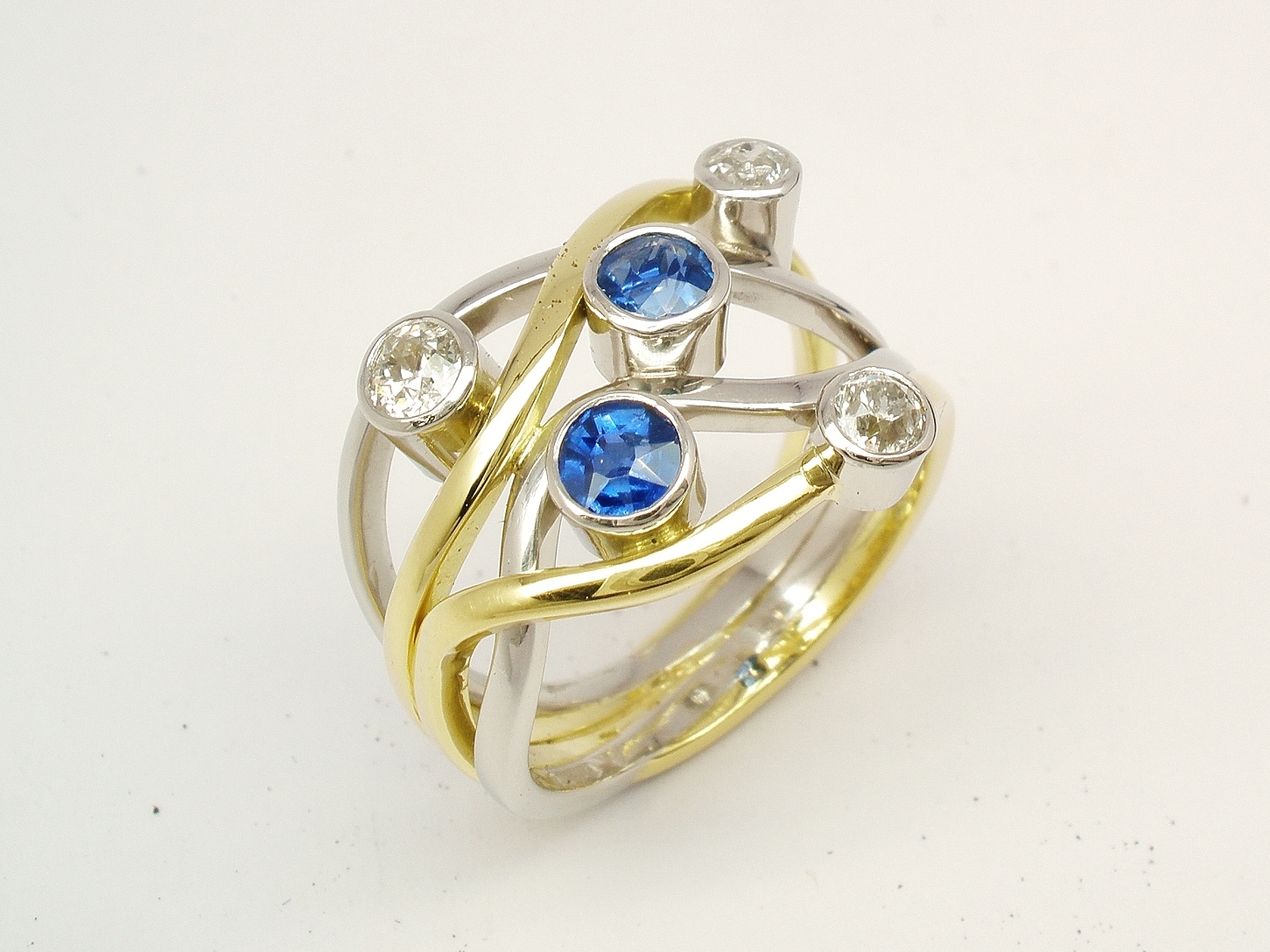 A 5 stone round sapphire and brilliant cut diamond 4 banded ring mounted in 18ct yellow gold and platinum.