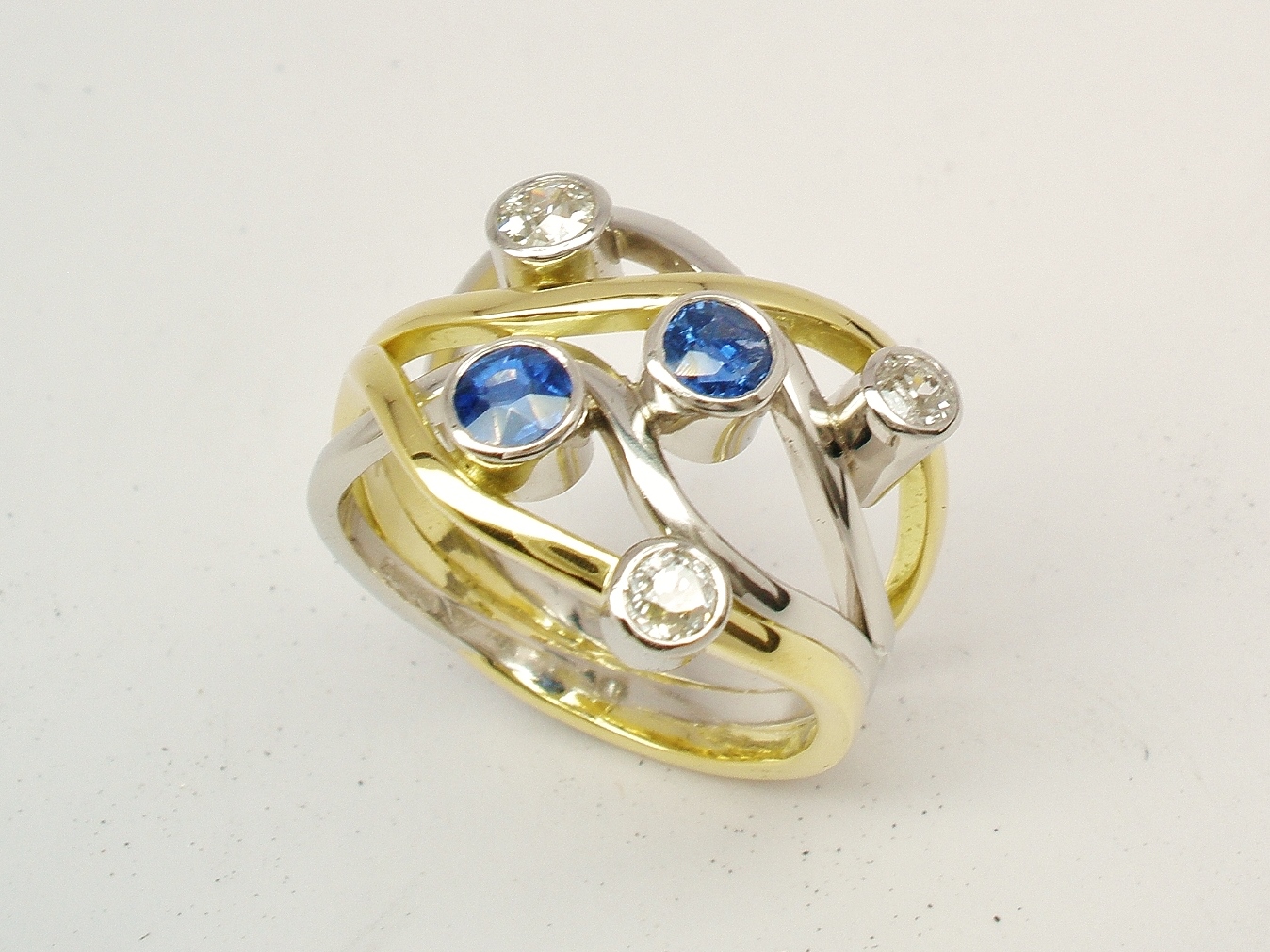 A 5 stone round sapphire and brilliant cut diamond 4 banded ring mounted in 18ct yellow gold and platinum.