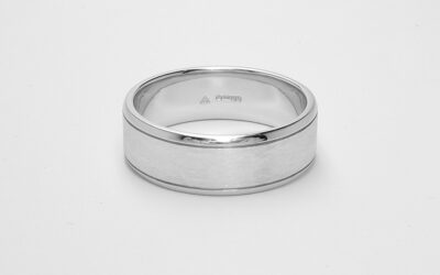 A gents 7mm broad platinum ring with lines cut 1.2mm i from both edges with polished edges and brushed finish centre.