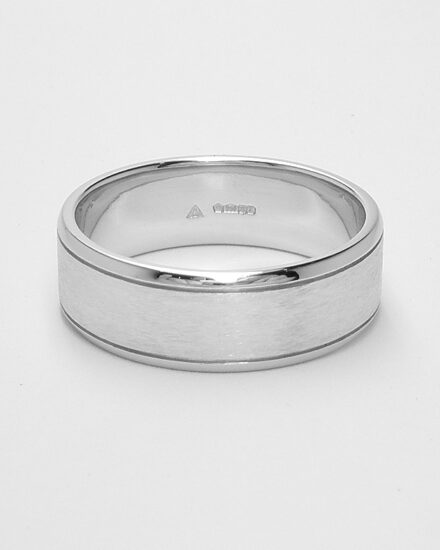 A gents 7mm broad platinum ring with lines cut 1.2mm i from both edges with polished edges and brushed finish centre.