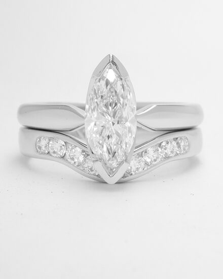 A 9 stone round brilliant cut diamond channel set ring mounted in platinum and shaped to fit with a single stone marquise diamond ring.