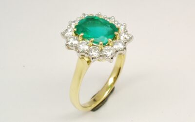 A 13 stone emerald cut emerald and round brilliant cut diamond ring mounted in 18ct. yellow gold and platinum.