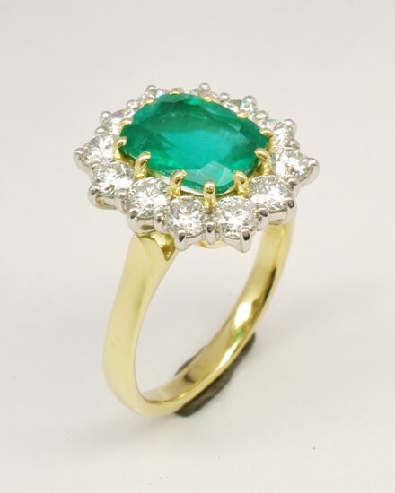 A 13 stone emerald cut emerald and round brilliant cut diamond ring mounted in 18ct. yellow gold and platinum.