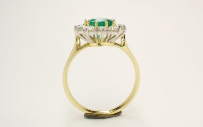 A 13 stone emerald cut emerald and round brilliant cut diamond ring mounted in 18ct. yellow gold and platinum.