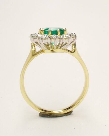 A 13 stone emerald cut emerald and round brilliant cut diamond ring mounted in 18ct. yellow gold and platinum.