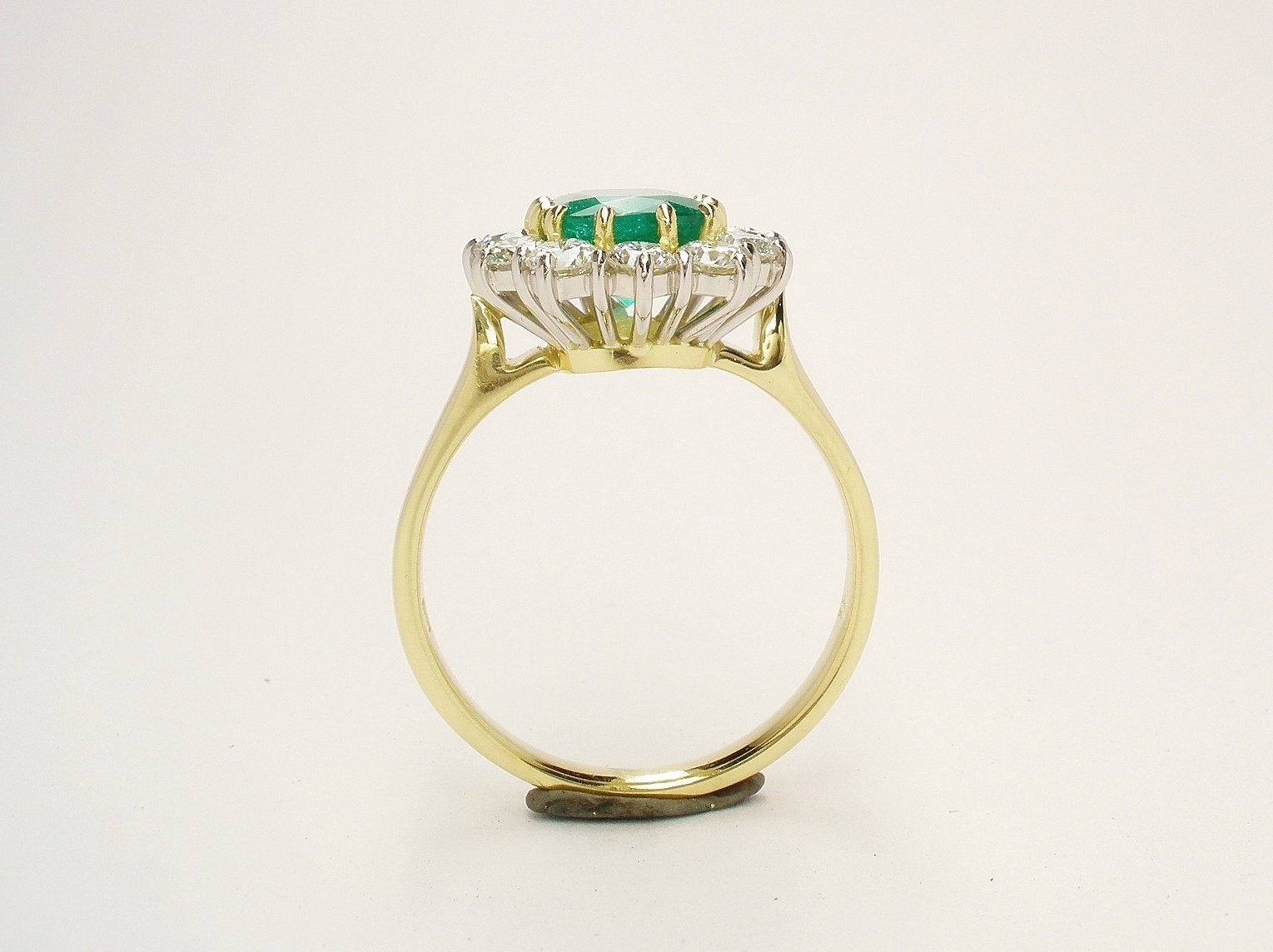 A 13 stone emerald cut emerald and round brilliant cut diamond ring mounted in 18ct. yellow gold and platinum.