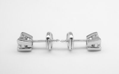 A pair of single stone princess cut diamond ear studs mounted in platinum with 'Guardian' comfort fit fittings.